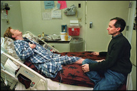 Marcia, exhausted, lies back in bed to rest  while her husband Bob watches helplessly. Bob spends every evening on weekdays and most of the day on weekends with Marcia in the hospital. - All images copyright Lisa Nipp 2010