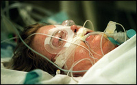 Swollen with fluids from surgery, Marcia lies unconscious in the Surgical Intensive Care Unit. Her chest cavity is open but covered by a protective wrap. - All images copyright Lisa Nipp 2010