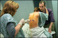Marcia nestles against Bob for support as Dr. Lisa Lancaster performs a thoracentesis to drain almost a liter of fluid off her right lung. Marcia's doctors are unsure why the fluid is building up in her lungs and worry it may indicate rejection. - All images copyright Lisa Nipp 2010